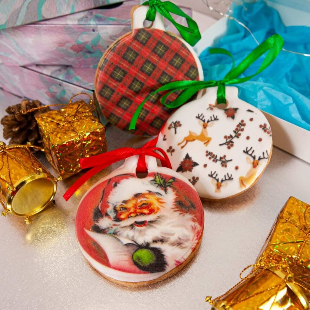 Galletas de Navidad personalizadas con forma de bola y lazos de colores, decoradas con Papá Noel, renos y cuadros escoceses
