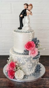 Tarta de Boda Divertida: Figura "Novio Pillado" y Rosas Fucsia